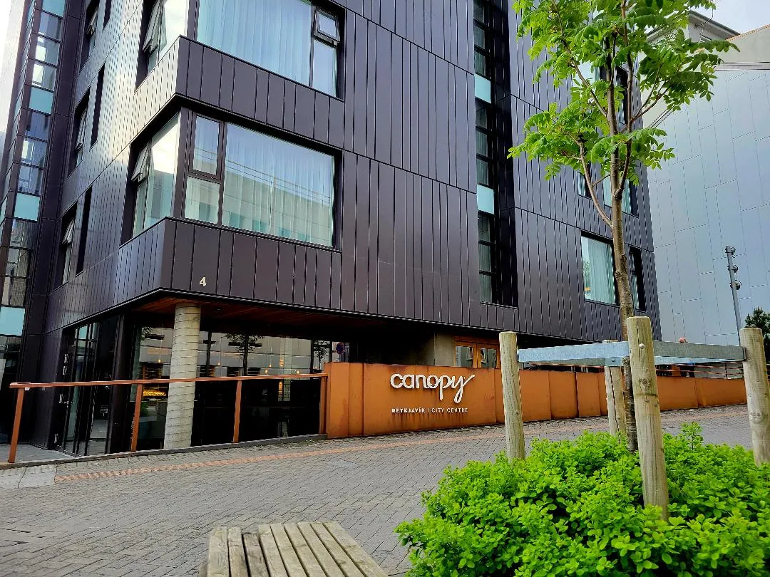 Canopy by Hilton Reykjavík City Centre — the dark zinc-clad boutique hotel with its lit 'canopy' sign, on a quiet street in Reykjavík's 101