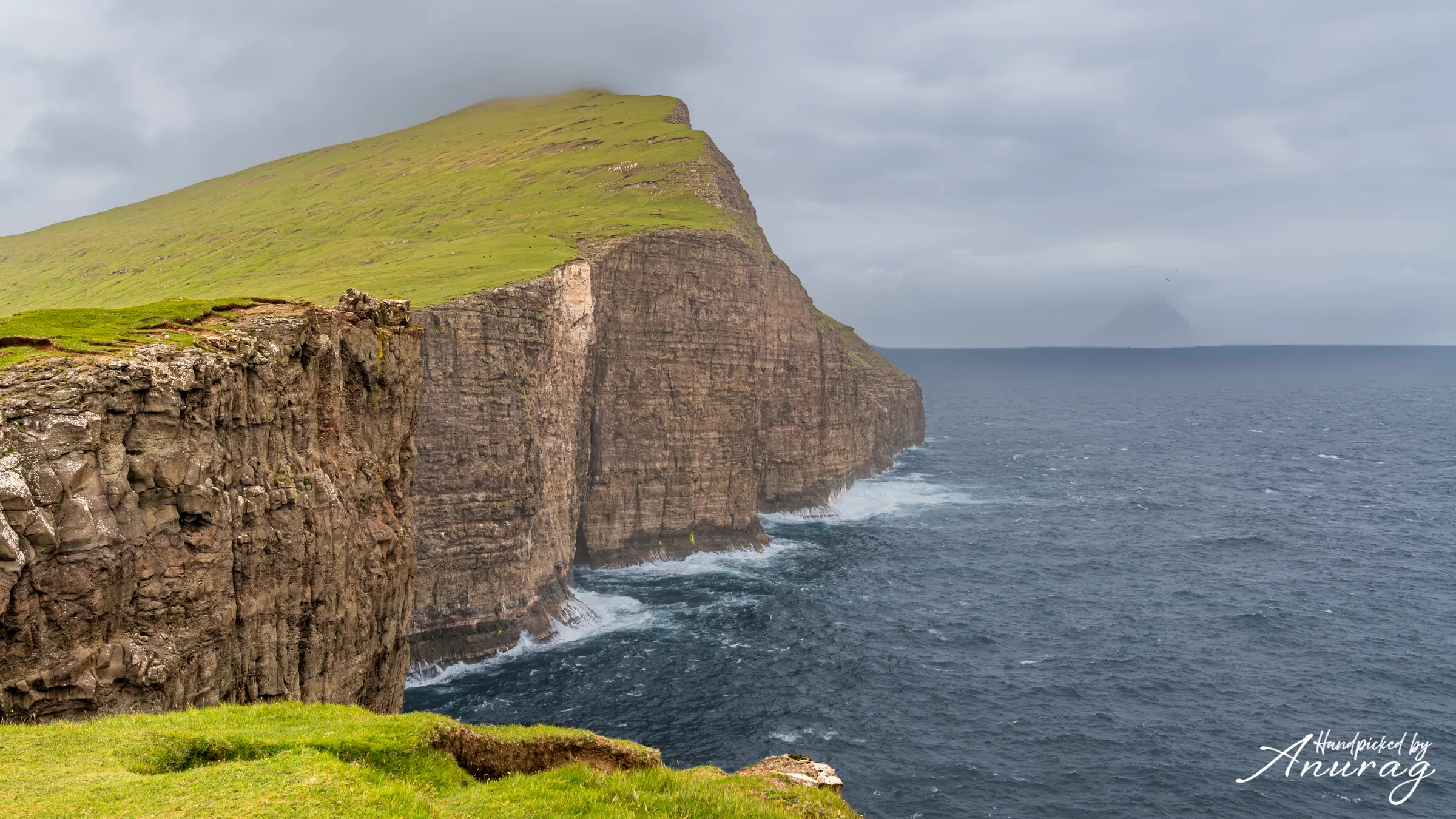 A waterfall plunging off a green cliff into the ocean